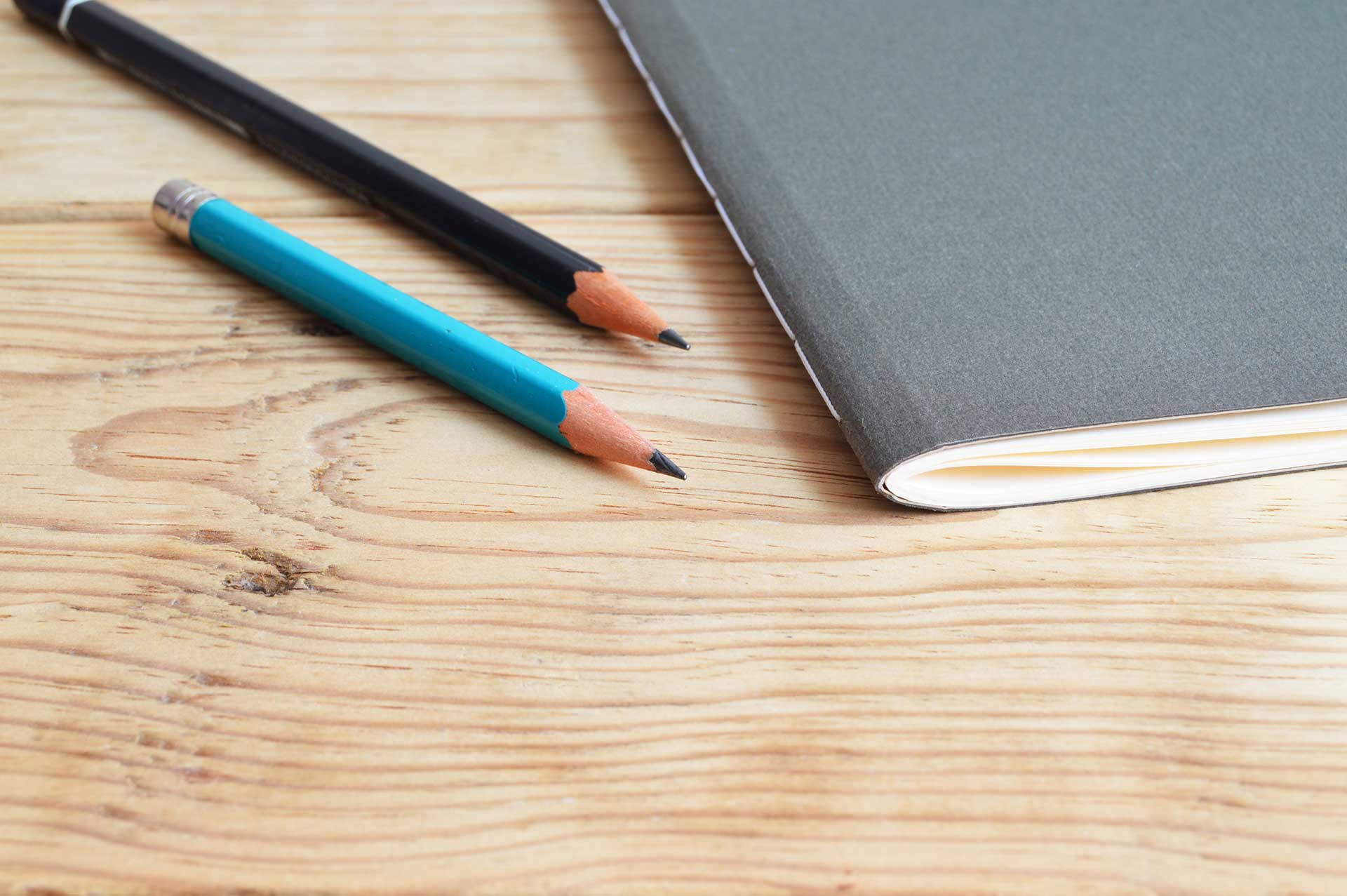 View of desk with pencils and a notebook